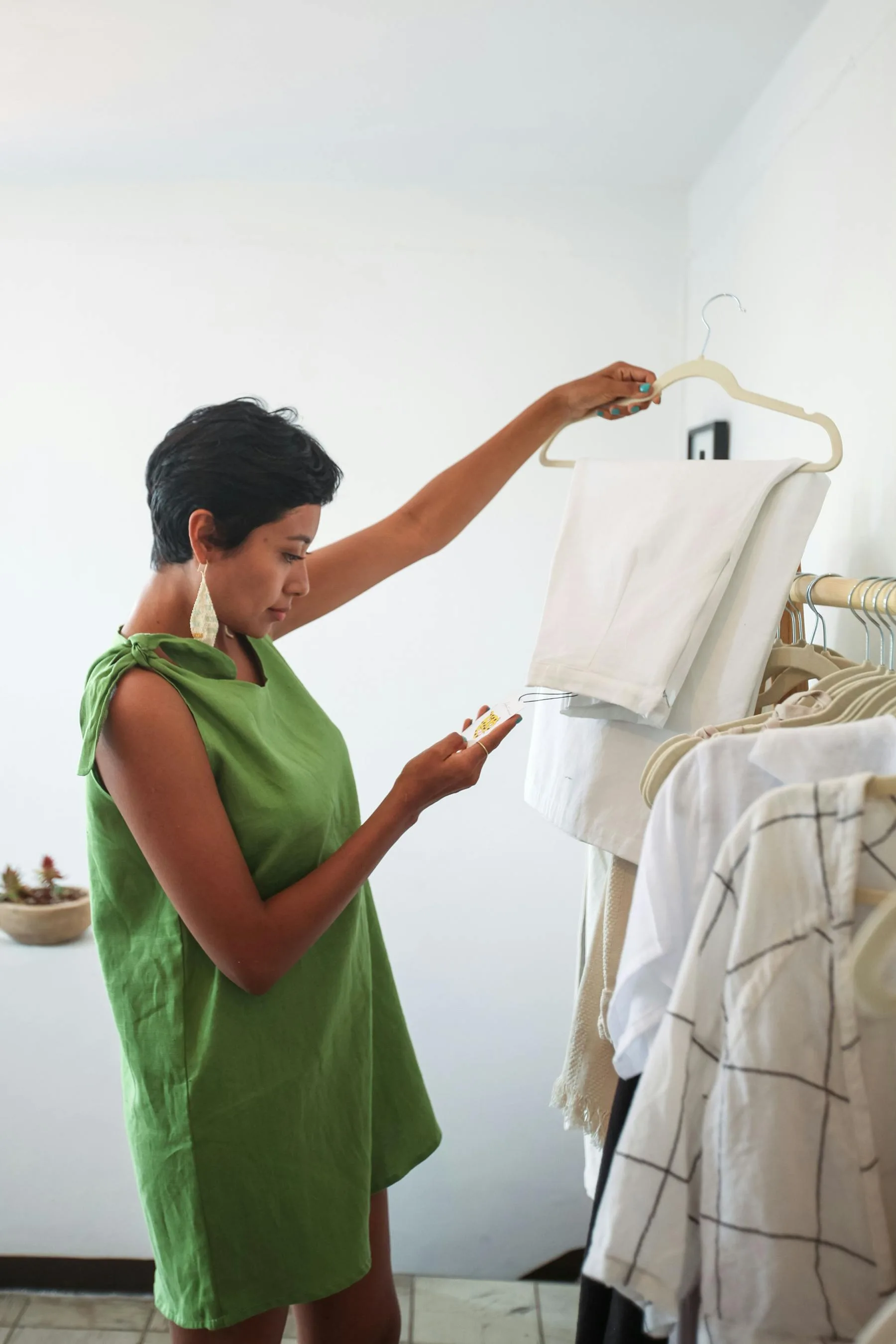 A green dress and clothing rack in a boutique setting